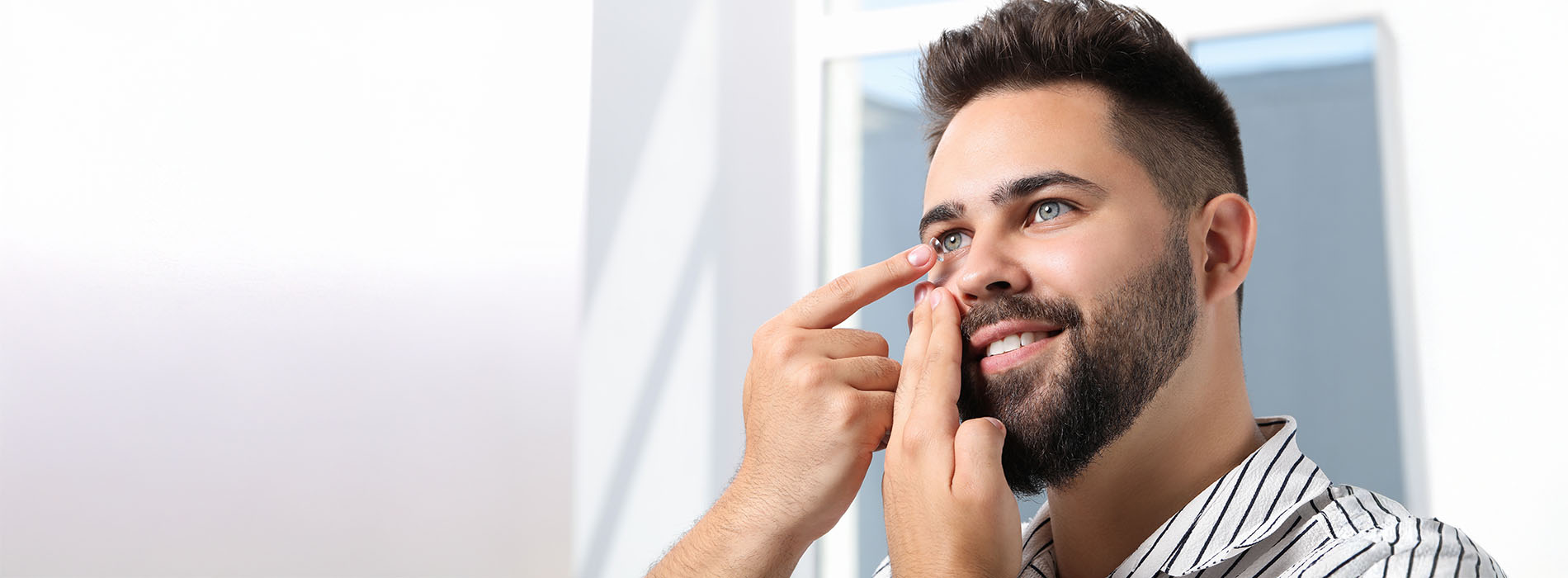 The image shows a man with a beard looking upwards while holding his nose, possibly indicating discomfort or an allergic reaction.