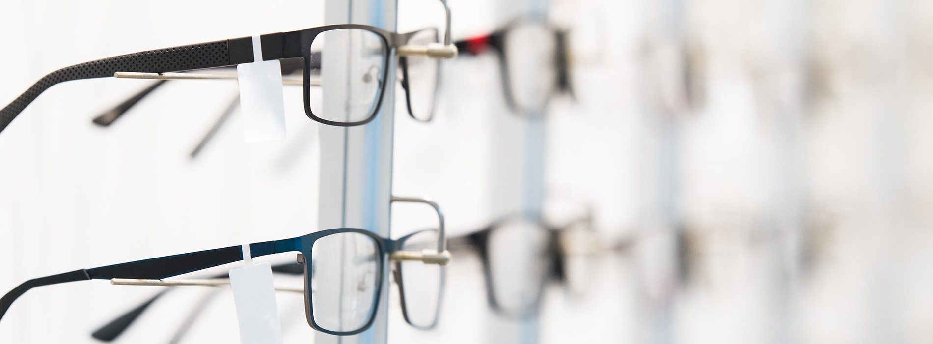 The image shows a row of eyeglasses with various frames displayed against a white background.